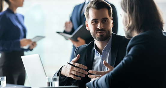 A group of business people talking at a meeting.