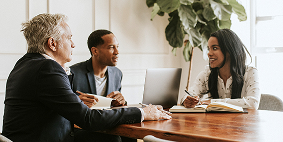 A group of people sitting around a table in an office.