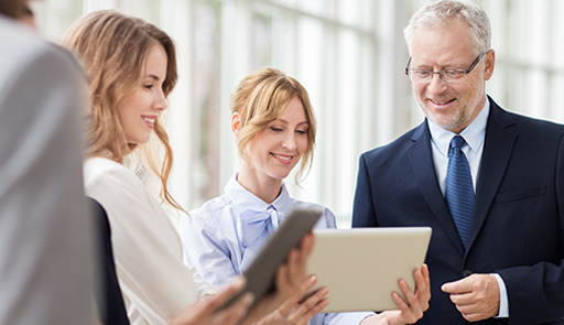 A group of business people looking at a tablet.